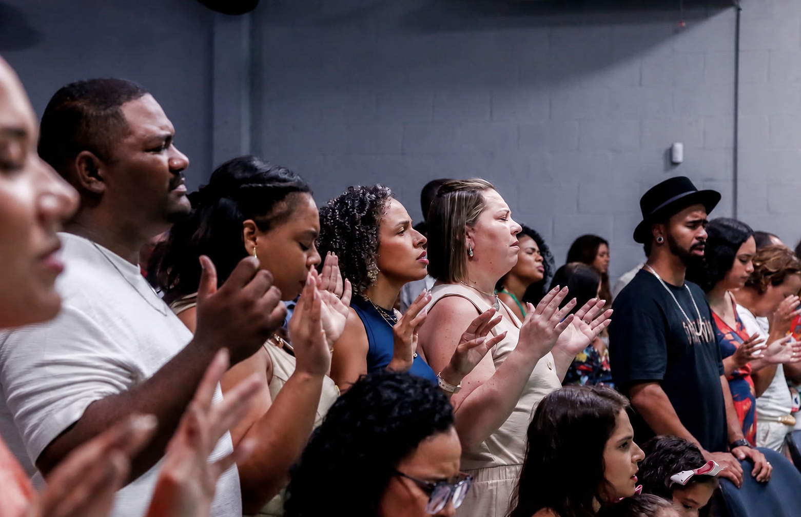 Comunidade da Farol da Cidade reunida em oração durante o culto